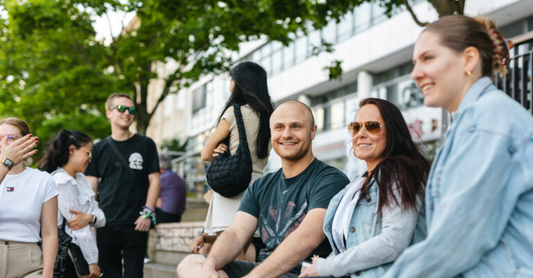 Studierende im Gespräch vor dem Hochschulgebäude