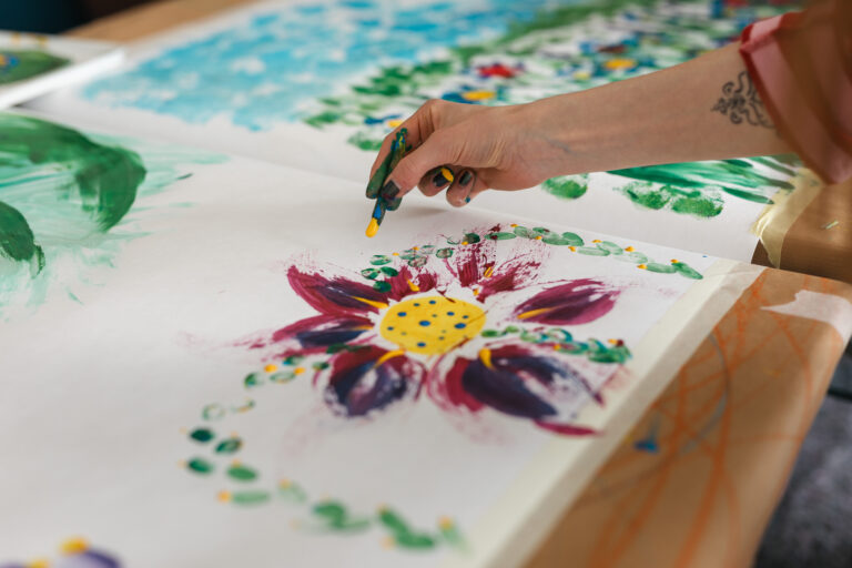 Hand bemalt eine Fliese mit einer bunten Blüte