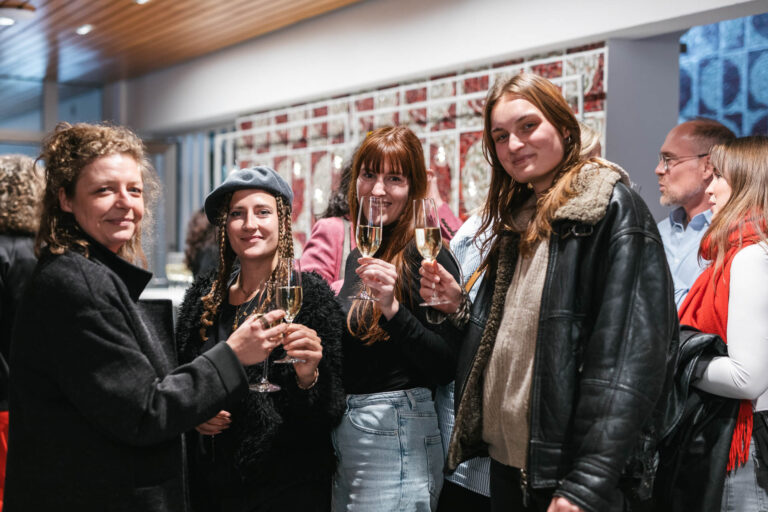 Studierende stoßen mit Sektgläsern an